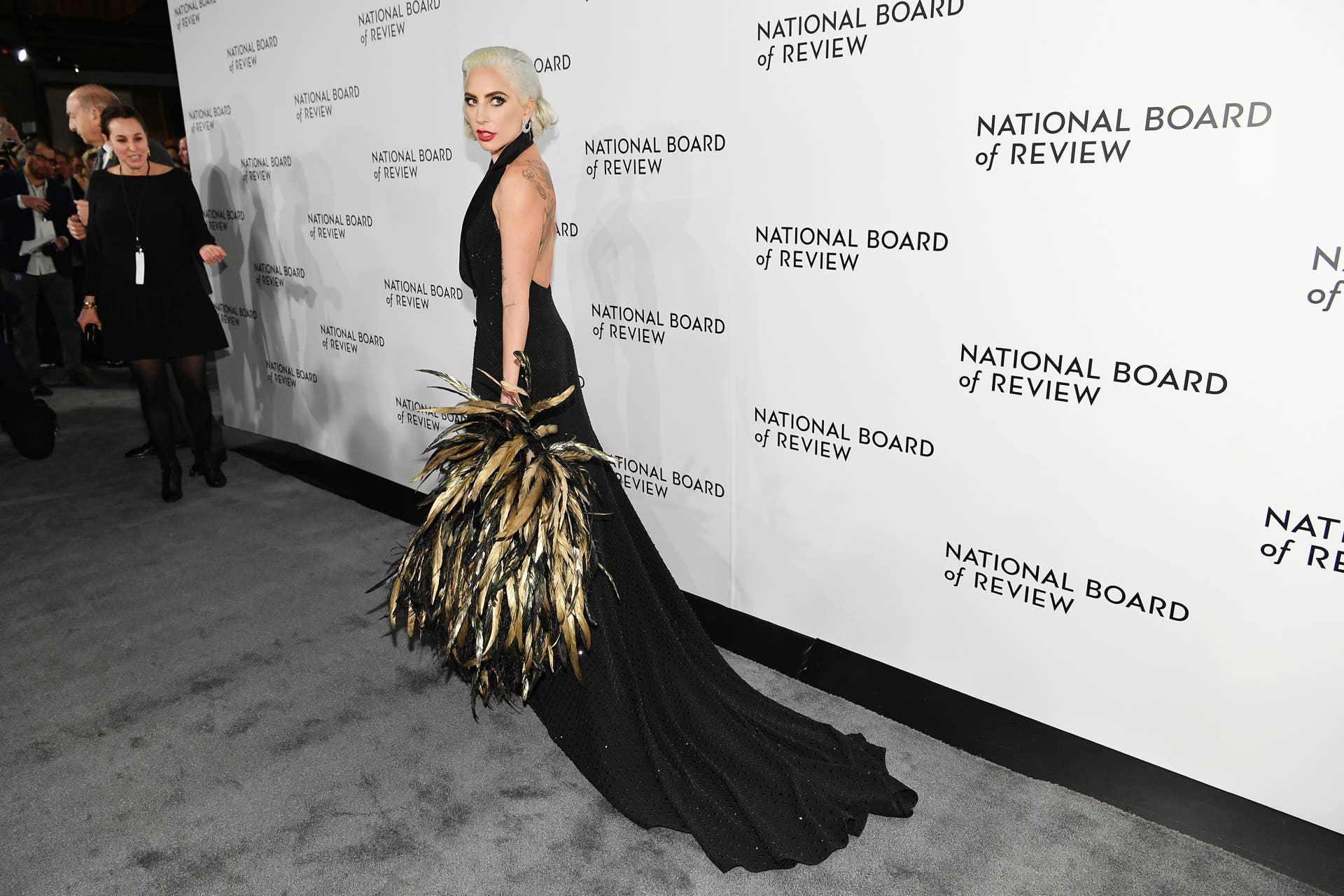 Lady Gaga Continues to Lean Into Superstar Style With a Crystal Tuxedo Dress  and Feathered Cape - Fashionista