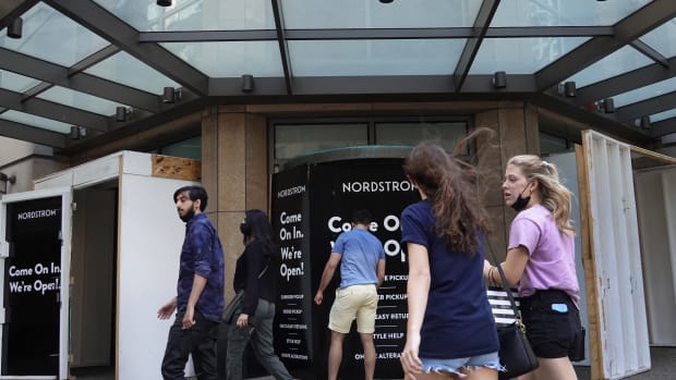 Pedestrians walk by the boarded up entrance of a Nordstrom store on May 26, 2021 in Chicago, Illinois.