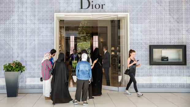 Shoppers wait outside a Dior store.