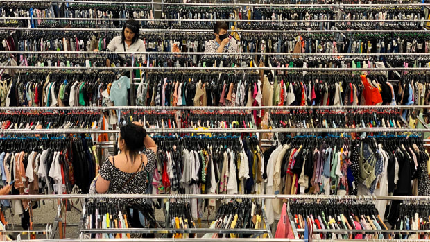 Customers shop between racks of clothing in the United States.