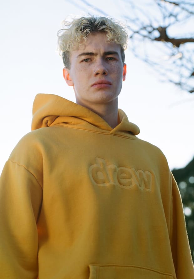 https://fashionista.com/.image/c_fit%2Ccs_srgb%2Cfl_progressive%2Cq_auto:good%2Cw_620/MTYyNDg1Mzc1NTAyMzI5NTEw/drew-house-2019-ski-doodle-hoodie-unisex-yellow-008_900x.jpg