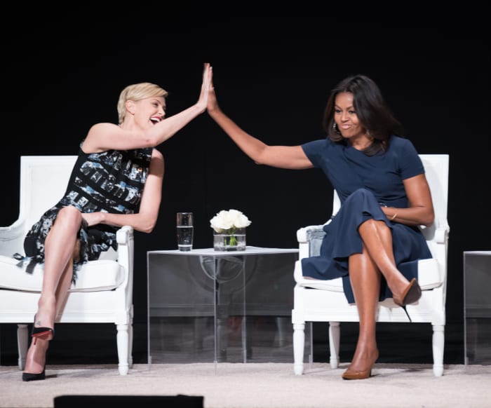 Charlize Theron and Michelle Obama high-five during "The Power of an Educated Girl" event. Photo: Dimitrios Kambouris/Getty Images for Glamour