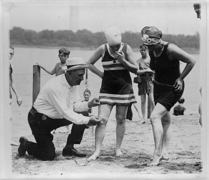Bill Norton, a bathing beach "cop," measures the distance between the hem of a woman's swimsuit and her knee on a Washington, D.C., beach in 1922. Photo: Library of Congress