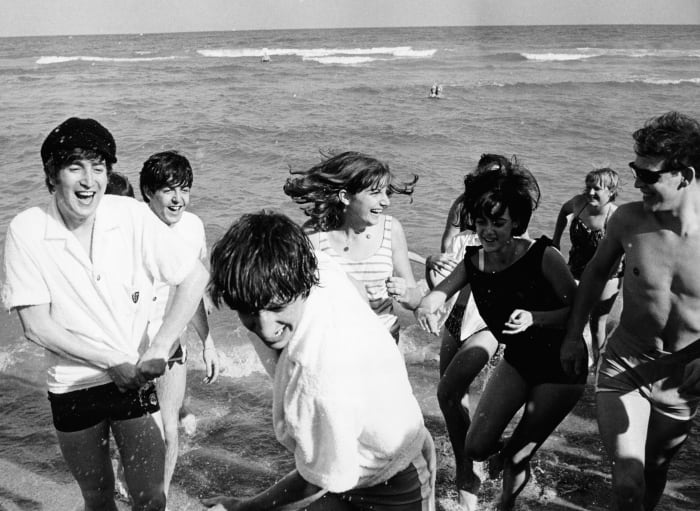The Beatles on a beach in Miami, Fla., surrounded by female fans, circa February 1964. Photo: Daily Express/Archive Photos/Getty Images