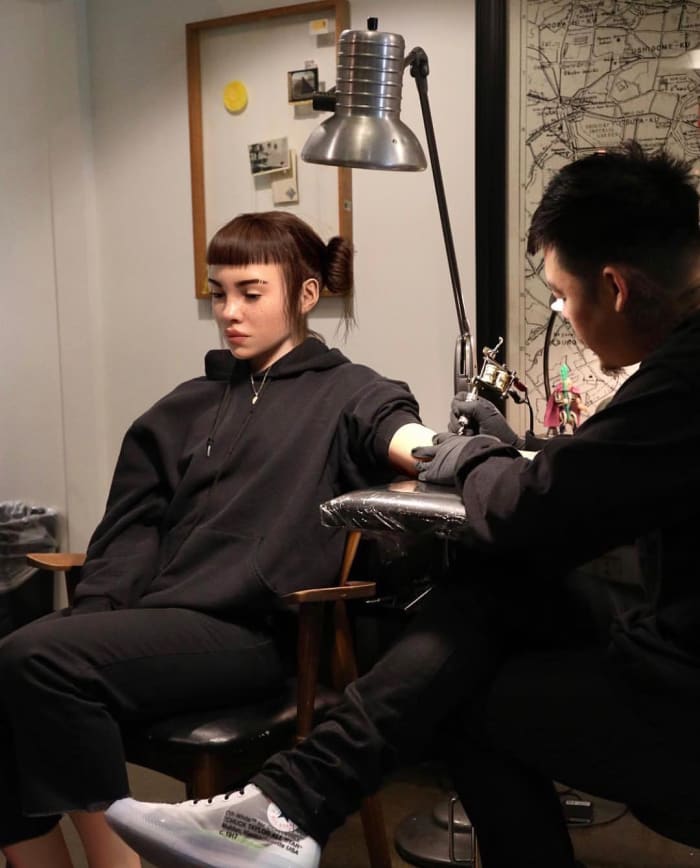 Dr. Woo tattooing Lil Miquela. Photo: @_dr_woo_/Instagram