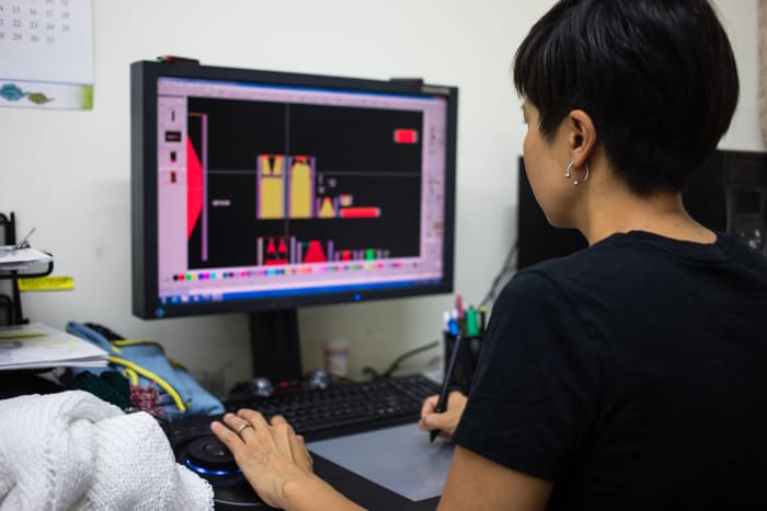Chu inputting a design into the program that sends data to the automatic knitting machines. Photo: Vicky Matthew/Fashionista