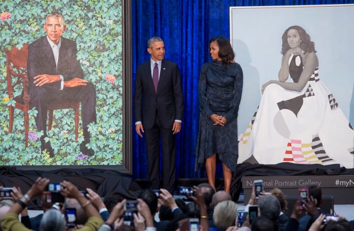 Former President Barack Obama and First Lady Michelle Obama stand beside their portraits by Kehinde Wiley and Amy Sherald after their unveiling. Photo: Saul Loeb/AFP/Getty Images