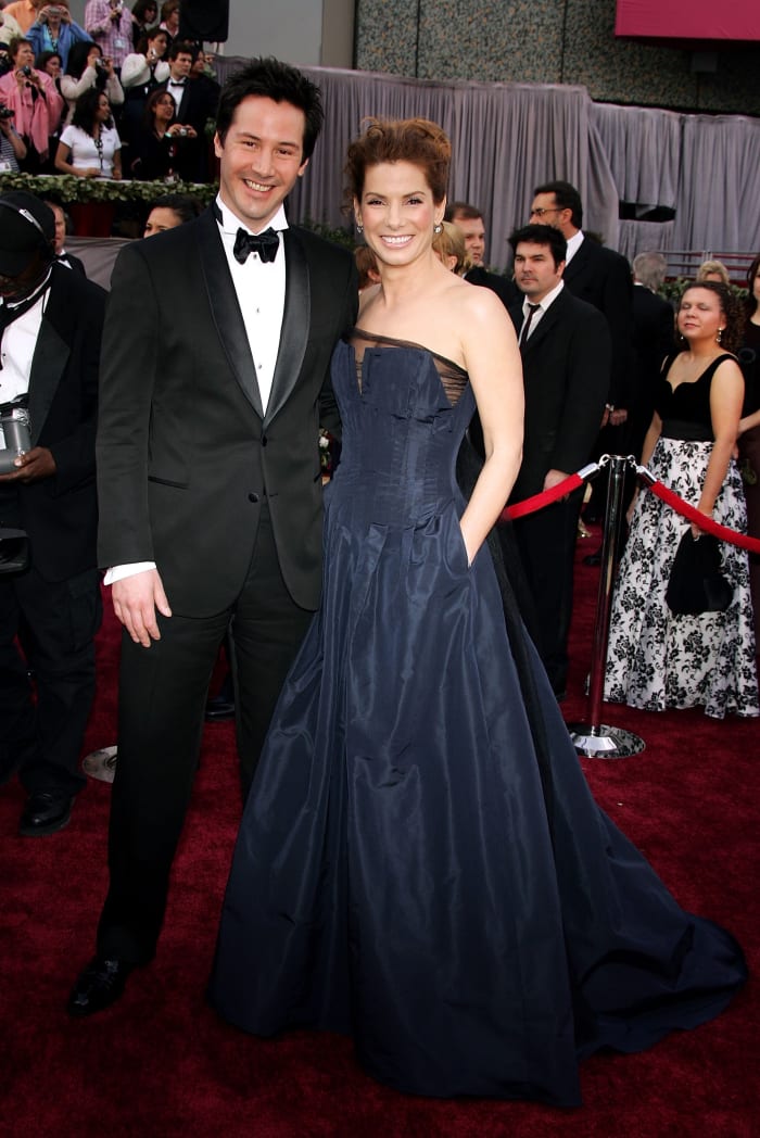 Reeves, styled in full Gucci by Yang, and Sandra Bullock at the 2006 Oscars. Photo: Frazer Harrison/Getty Images)