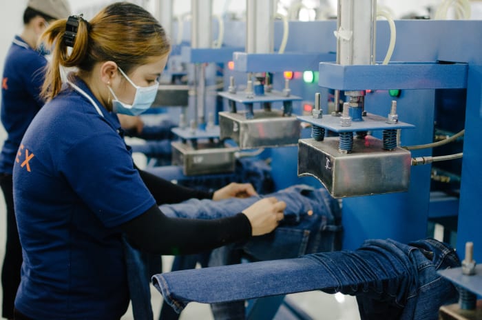 The metal blocks on the top of this machine apply heat and pressure to achieve a worn-in look. Photo: Whitney Bauck/Fashionista