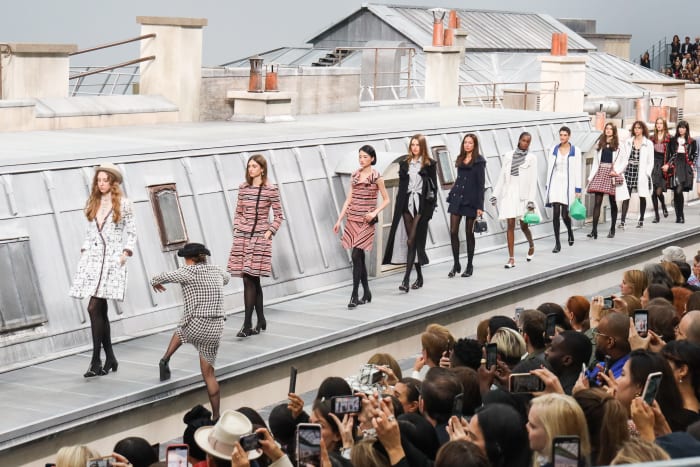 A woman from the audience climbs the runway to walk with the models during the finale of the Chanel Spring 2020 show. Photo: Victor Boyko/Getty Images