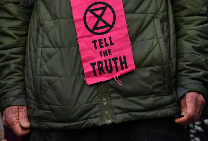 Extinction Rebellion protestors are encouraged by organizers to wear slogans printed on deadstock fabric or garments. Photo: Paul Ellis/AFP/Getty Images