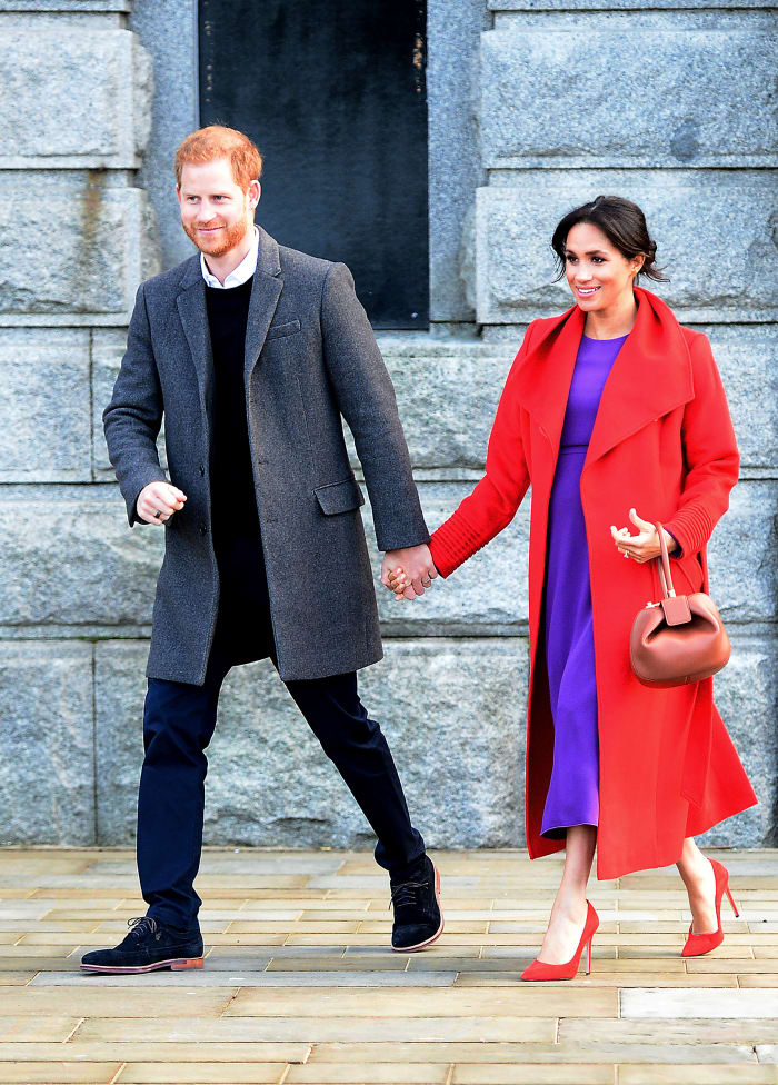 Prince Harry, Duke of Sussex, and Meghan, Duchess of Sussex, in Birkenhead, England. The Duchess is wearing a Sentaler coat, Aritzia dress, Stuart Weitzman heels and a Gabriela Hearst handbag. Photo: Richard Martin-Roberts/Getty Images