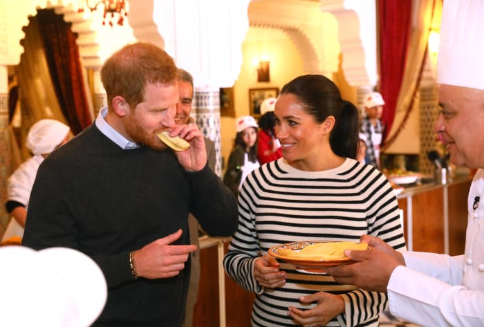 Prince Harry and Meghan Markle in Equipment try some food as they visit a cooking demonstration, where children from under-privileged backgrounds learn traditional Moroccan recipes. Photo: Tim P. Whitby - Pool/Getty Images