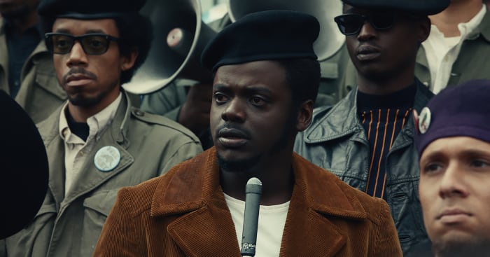 Chairman Fred (center) with Cha Cha Jimenez (Nicholas Velez), in the Young Lords purple beret, in the bottom right hand corner.