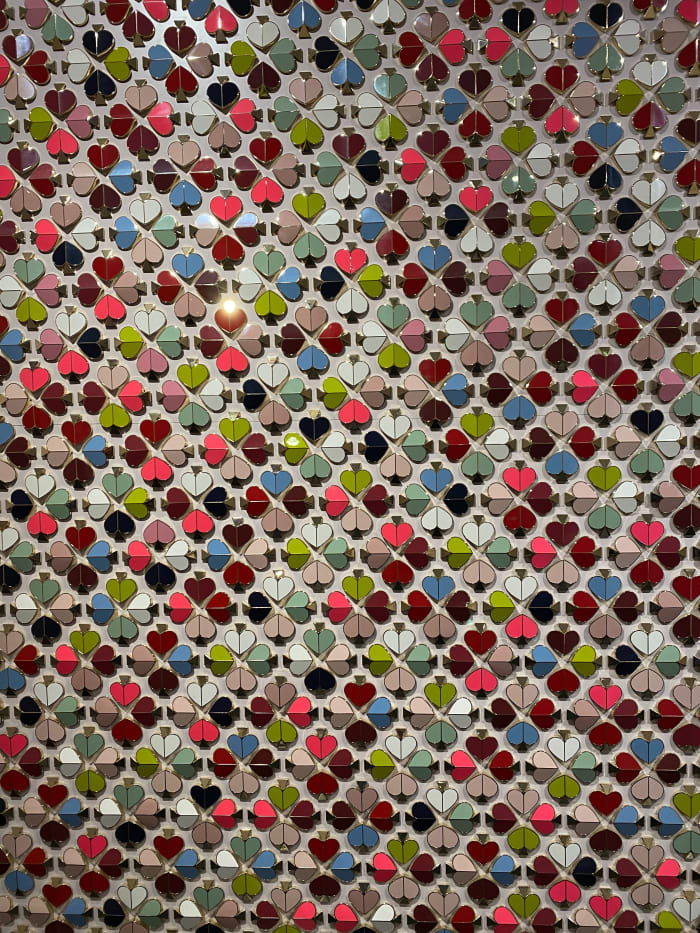 A wall with Kate Spade New York hardware decorates the reception area at the brand's offices.