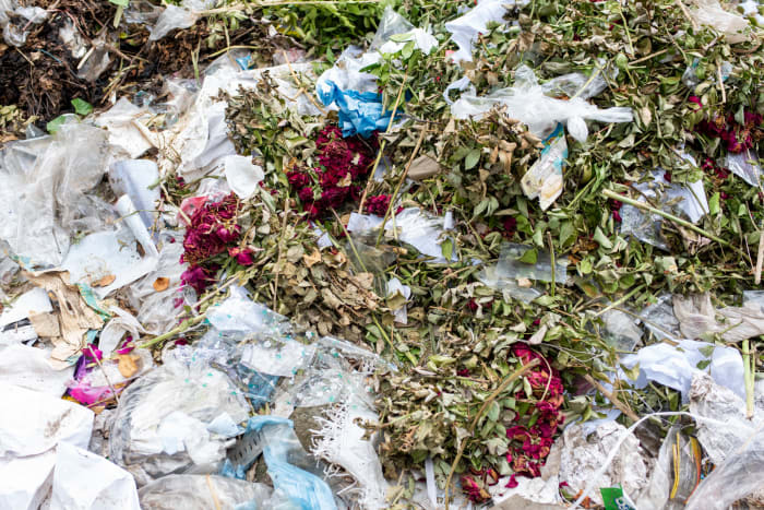 A pile of dried flowers from the previous year's memorial at the Rana Plaza memorial site. These were likely left by family members of the victims.