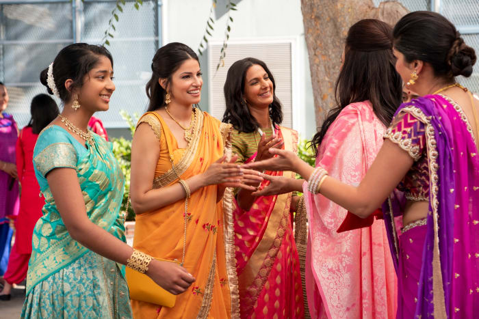 Devi, Kamala (Richa Moorjani) and Nalini (Poorna Jagannathan) greet the aunties at Ganesh Puja.