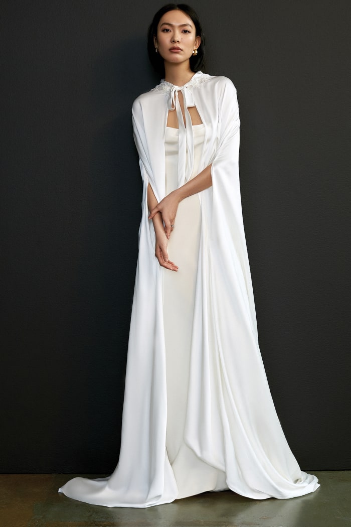 A cape and wedding dress from the Savannah Miller Spring 2021 collection.