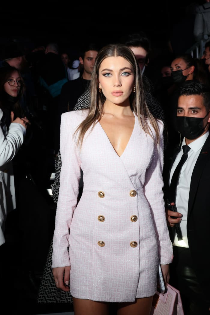Amelie Zilber wearing a pink monogram Balmain blazer dress to the brand's Spring 2022 show during Paris Fashion Week.