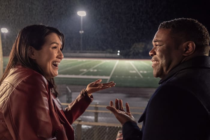 Zoe (Zoe Chao) and Aniq (Sam Richardson) have a moment, against very 'Four Weddings and a Funeral'-esque rainfall.