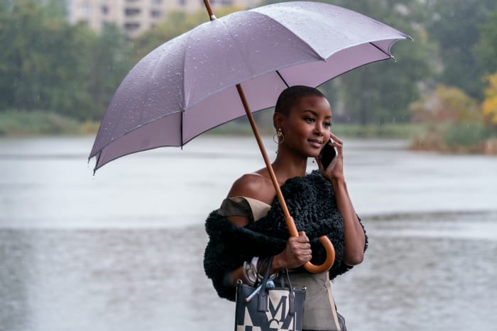 Ella (Andrea Bordeaux) prepared for the rainy commute, with cameo from her Schutz sparkly shoe in her MCM bag.