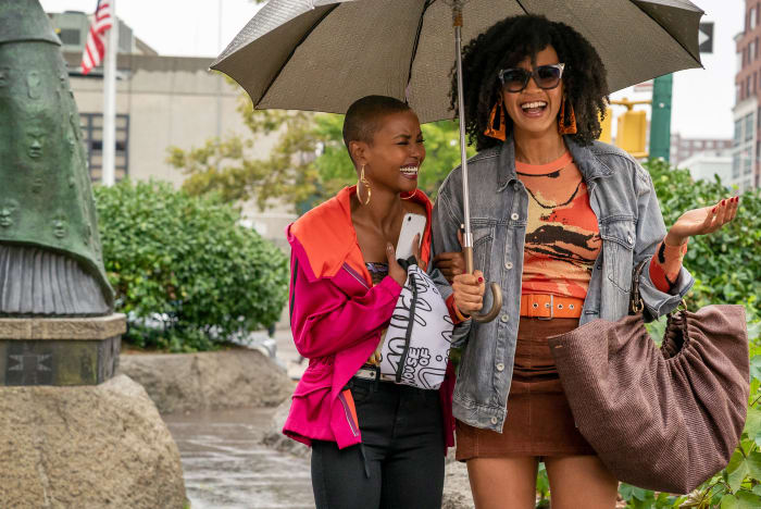 Ella, in a Dries Van Noten anorak, over a Biggie Smalls T-shirt corset from Patricia Field's vintage line, walking with Sondi (Corbin Reid) and carrying a House of Field belt bag.
