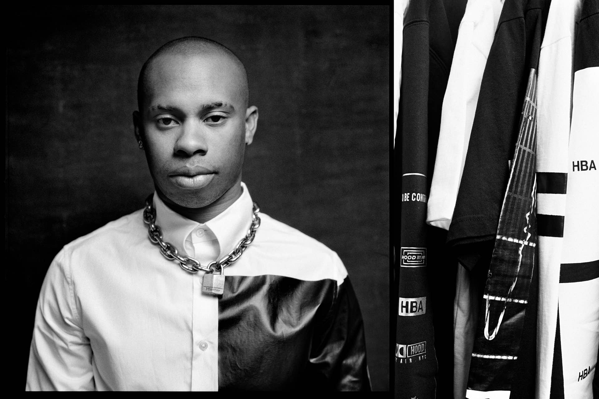 Shayne Oliver poses for a photo next to a collection of Hood By Air clothing.
