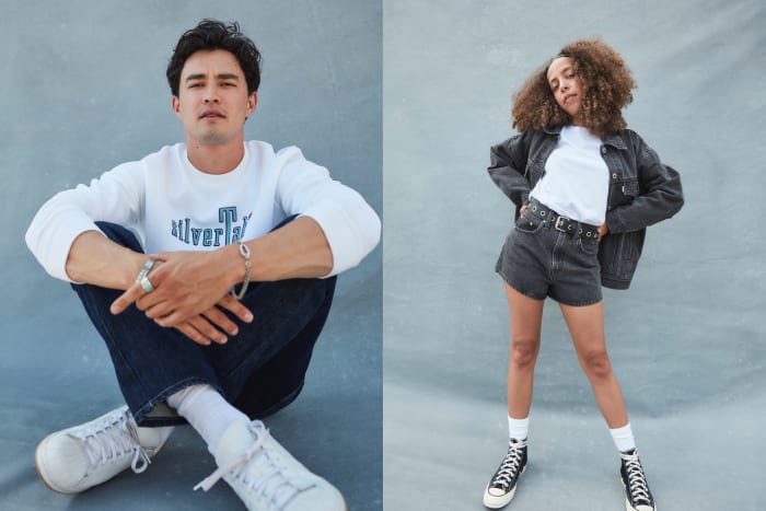 Gavin Leatherwood sits in a white sweatshirt and dark wash denim jeans with white sneakers on the left, while Hayley Law wears a white t-shirt with a gray denim jacket and gray denim shorts.  Law also wears white socks and black lace-up sneakers.