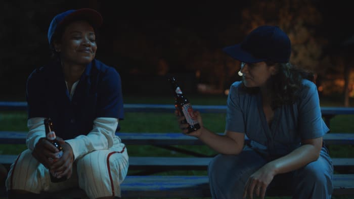 Pitcher Max (Chanté Adams) and catcher Carson bond over a beer and baseball.