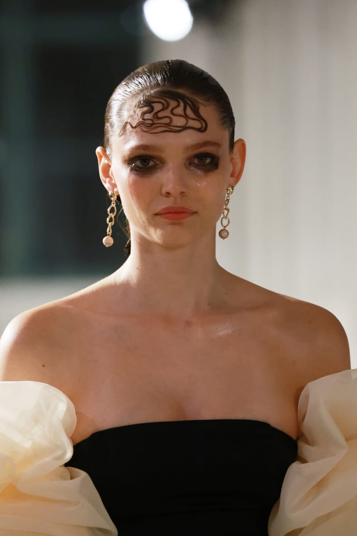 Foreheads plastered with wave-mimicking hair designs and heavy black makeup to invoke a sense of grief.