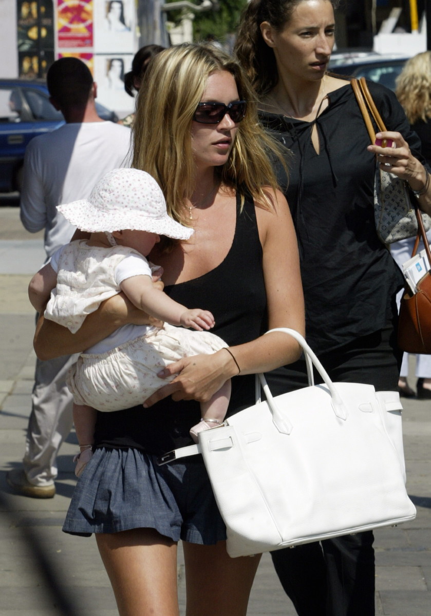 Model Kate Moss walks with her daughter Lola and a Birkin bag in 2003. Photo: Aura/Getty Images