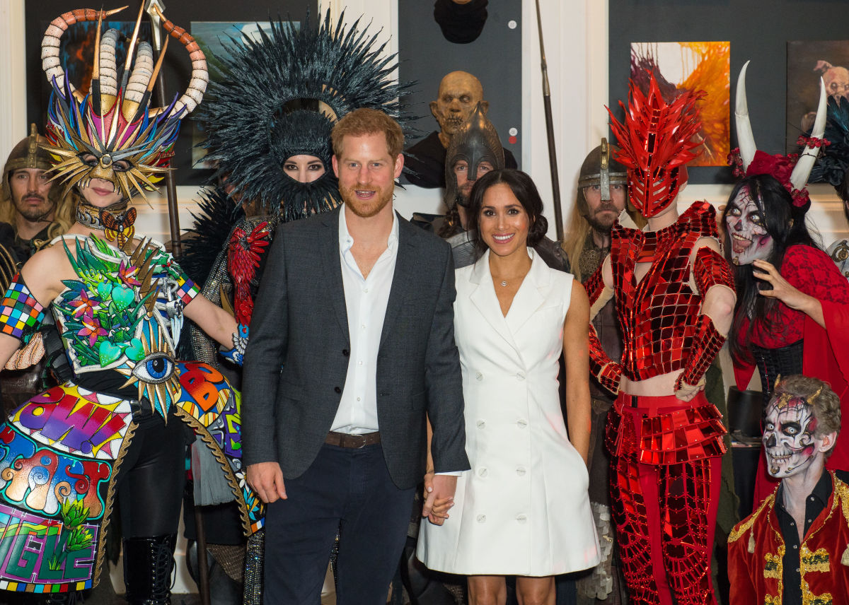 Prince Harry and Meghan Markle (in Maggie Marilyn) pose with models wearing costumes during a visit to Courtenay Creative in Wellington, New Zealand. Photo: Dominic Lipinski - Pool/Getty Images