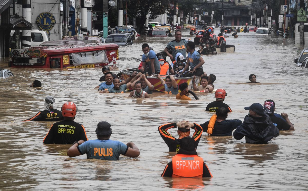 Rescuers pull a rubber boat carrying residents through a flooded street after Typhoon Ulysses hit Marikina on November 12, 2020.