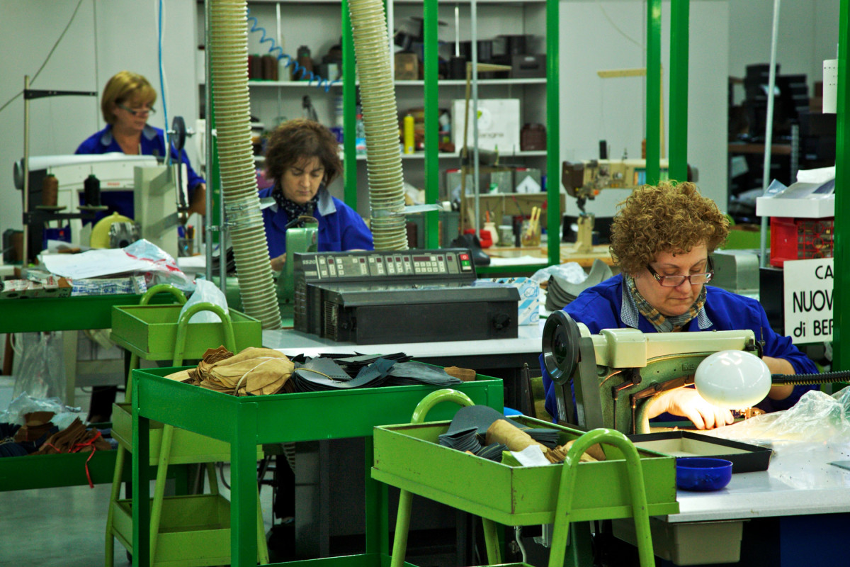 Employees use machines to manufacture footwear at a factory in Corridonia, Italy.