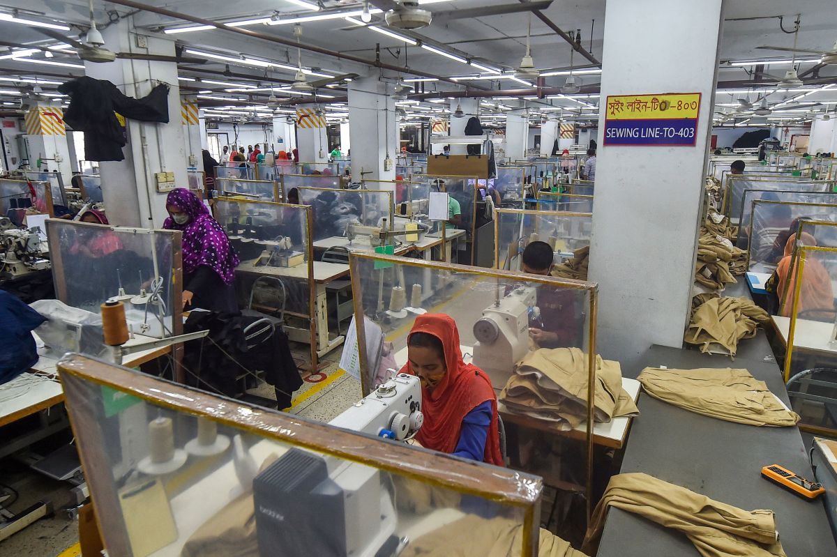 Labourers work at their stations separated by partitions as a preventive measure against the Covid-19 coronavirus at the Civil Engineers Limited garments factory in Dhaka