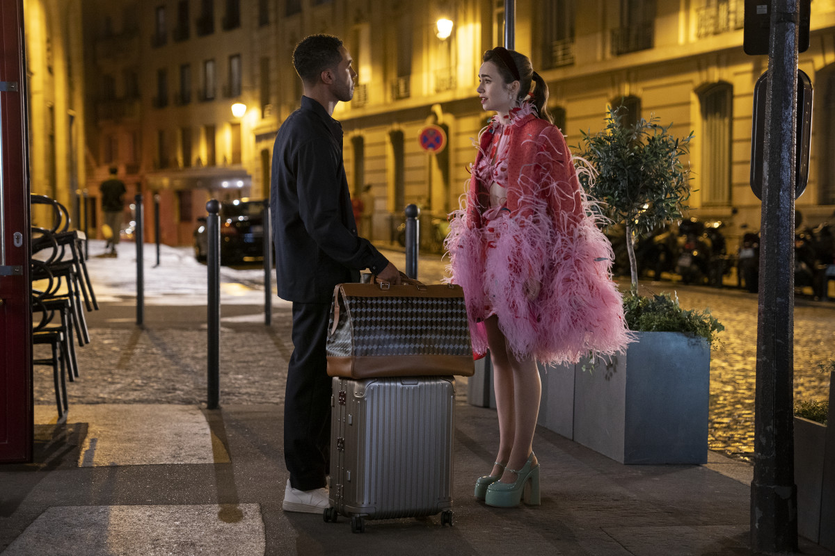 Alfie (Lucien Laviscount) confronts a post-dinner Emily (Lily Collins), in a custom cape, over a Magda Butrym dress, with custom Christian Louboutin platforms.