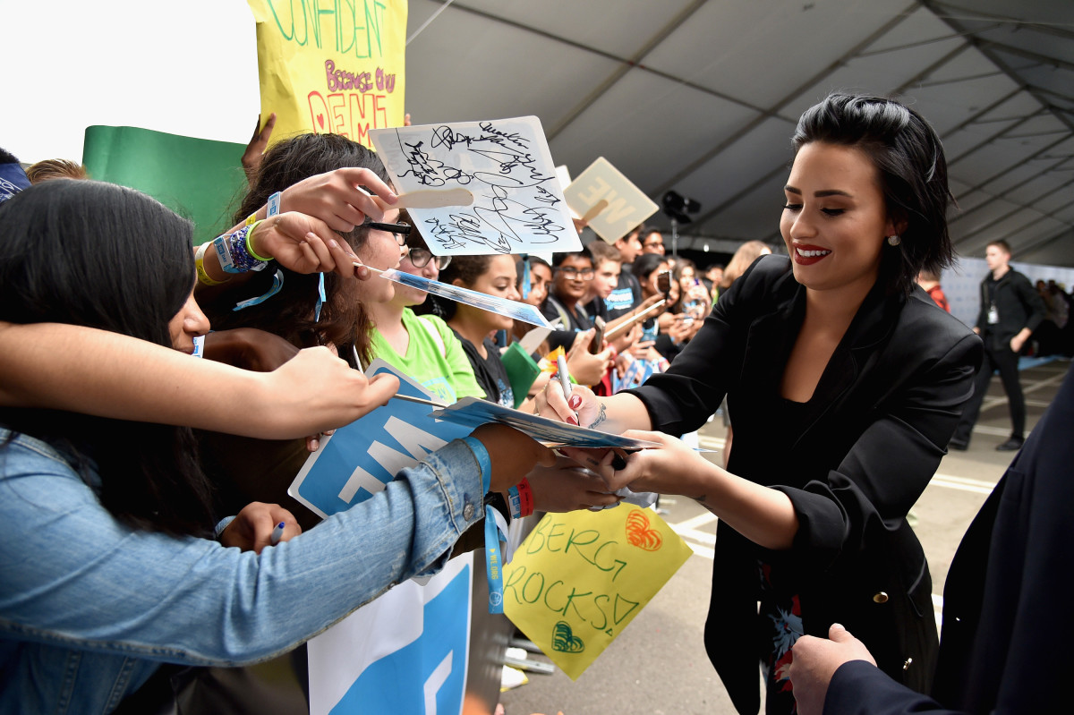 Demi Lovato signs photos for fans.